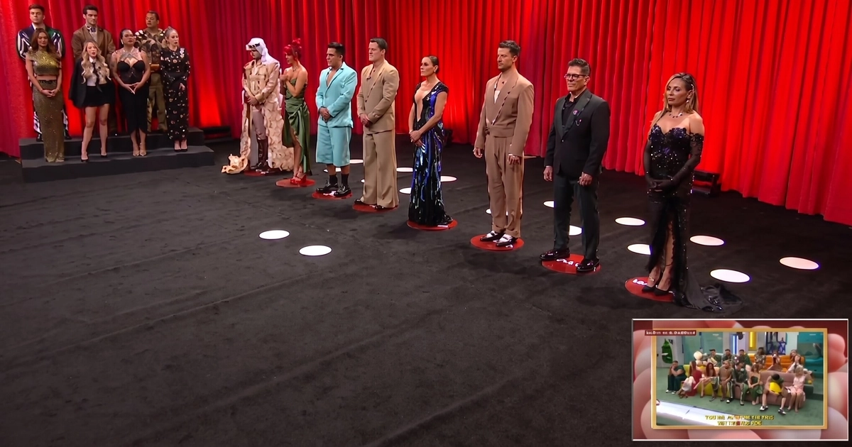 Un grupo de concursantes vestidos de gala permanece de pie sobre un escenario de televisión con fondo de cortinas rojas. (Imagen Ilustrativa Infobae)