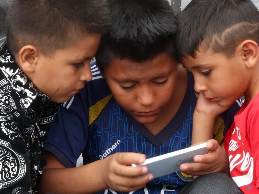 Niños observan un videojuego en el celular, en Ciudad de México, en julio de 2025. Moisés Pablo Nava (Cuartoscuro)