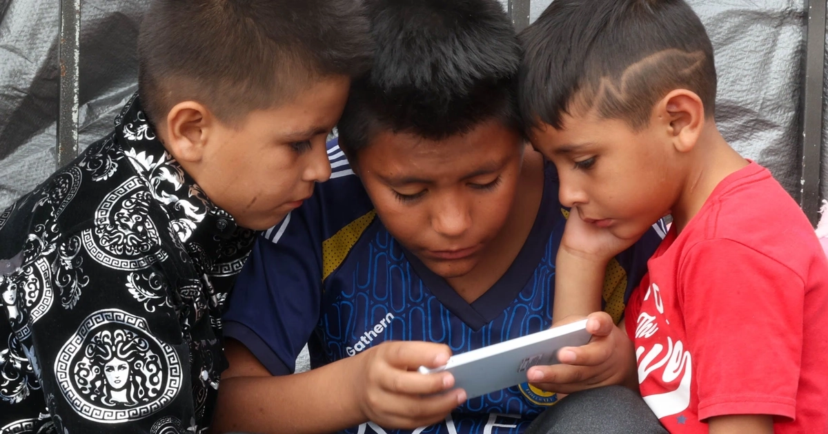 Niños observan un videojuego en el celular, en Ciudad de México, en julio de 2025. Moisés Pablo Nava (Cuartoscuro)