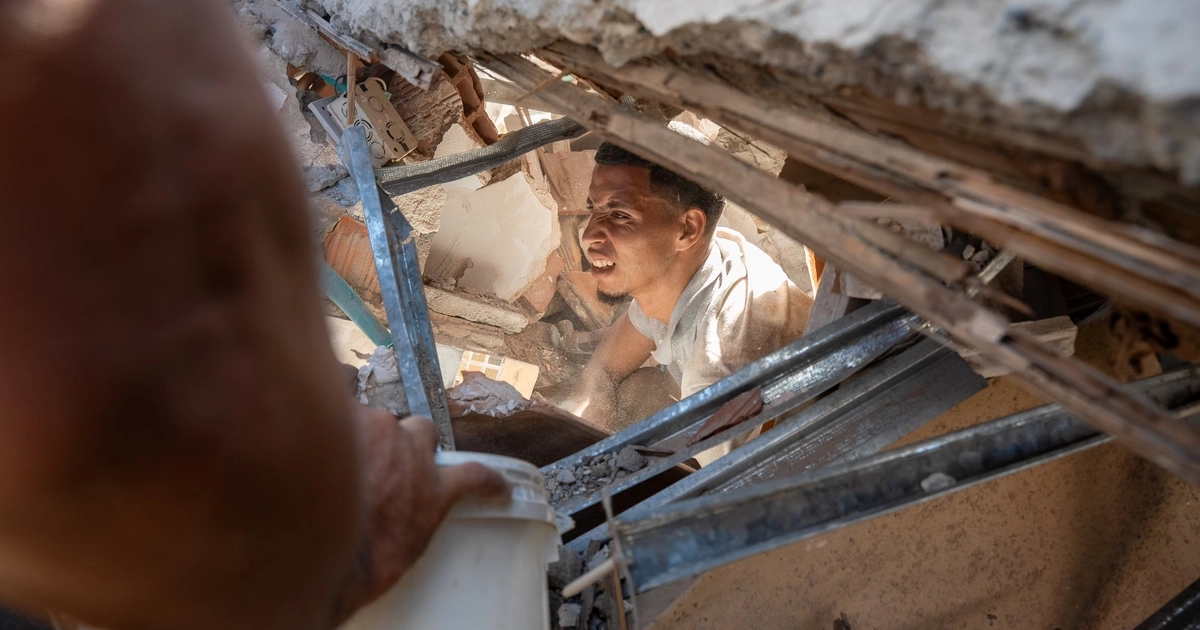 Un hombre busca sobrevivientes entre los escombros de un edificio, en Cali.