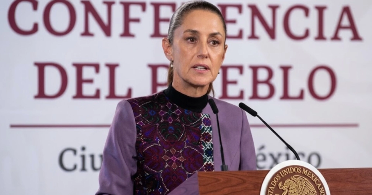 Claudia Sheinbaum habla tras un podio con el escudo de México, frente a un panel con las palabras Conferencia del Pueblo