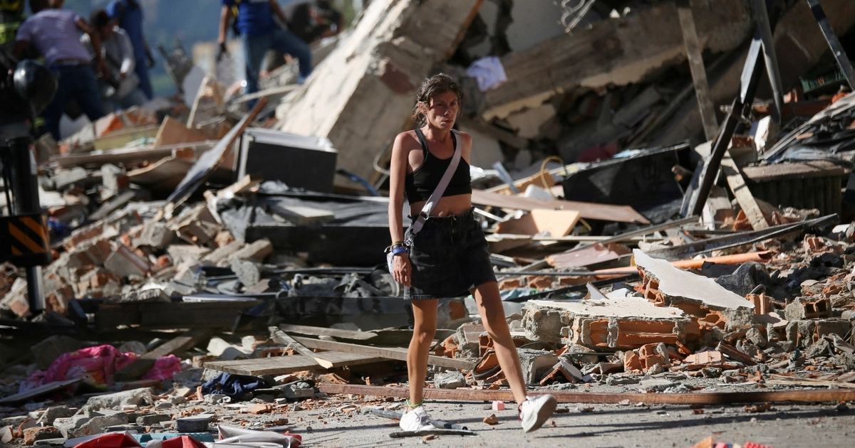 Una mujer pasa junto a los escombros de unos edificios derrumbados tras un terremoto, en Pereira (Colombia), el 10 de agosto de 2026. REUTERS/Juan David Duque