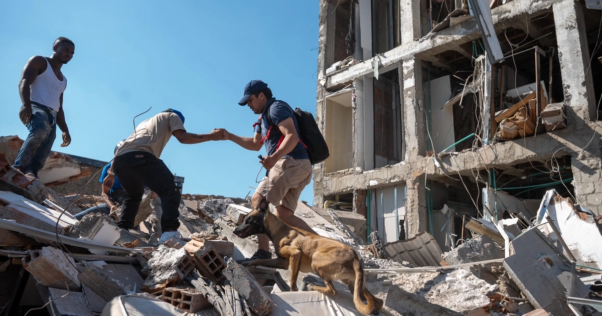 Varias personas buscan sobrevivientes en un edificio, en Cali.