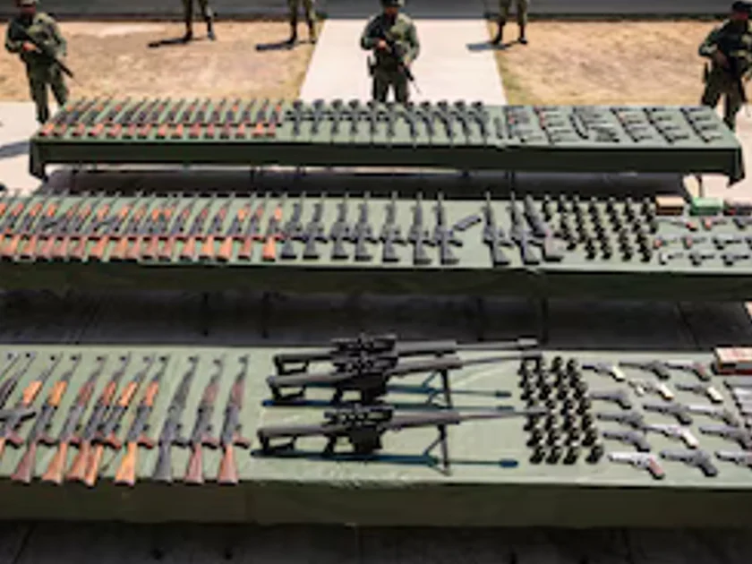 Soldados del Ejército Mexicano custodian varias mesas alineadas con fusiles de asalto, pistolas, granadas y municiones decomisados. (Imagen Ilustrativa Infobae)