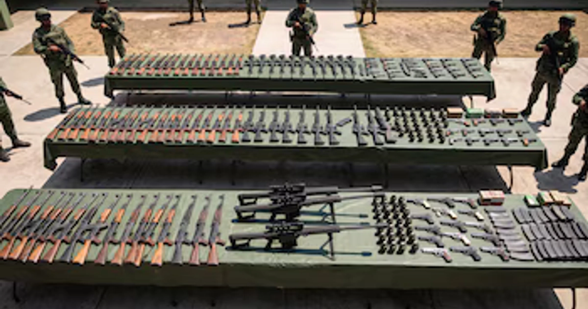 Soldados del Ejército Mexicano custodian varias mesas alineadas con fusiles de asalto, pistolas, granadas y municiones decomisados. (Imagen Ilustrativa Infobae)