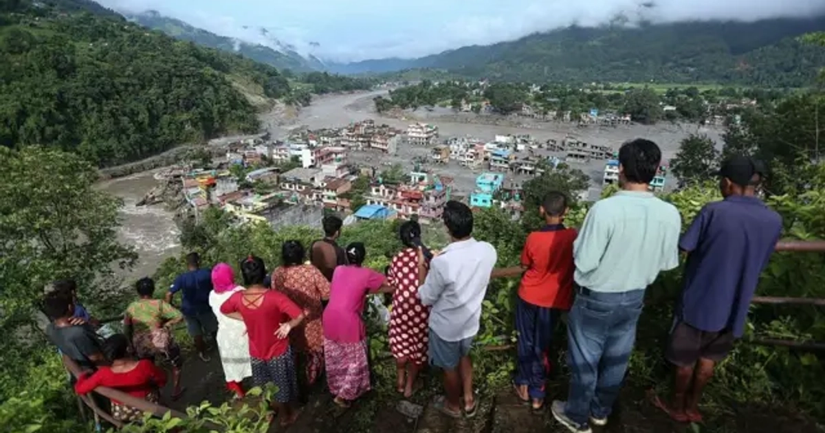 Las víctimas de las inundaciones observan desde lo alto de una colina cómo sus hogares permanecen sumergidos en Nuwakot (Nepal), el 27 de agosto de 2026, tras el desbordamiento de un lago glaciar en el Tíbet.