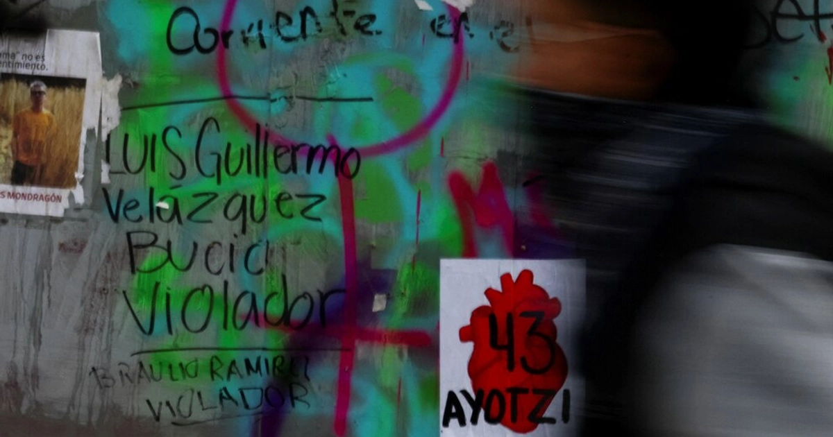 A person walks past a wall with the names of disappeared students written on it, during a protest by students from the Raul Isidro Burgos Rural Teachers' College in Ayotzinapa, marking the 12th anniversary of the disappearance of 43 students, in Mexico City, Mexico, September 26, 2026. REUTERS/Quetzalli Nicte-Ha