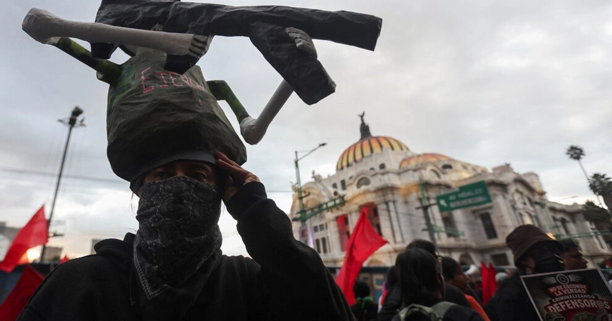 A demonstrator wearing a headdress depicting a skeleton holding a gun takes part in a protest by students from the Raul Isidro Burgos Rural Teachers' College in Ayotzinapa, marking the 12th anniversary of the disappearance of 43 students, in Mexico City, Mexico, September 26, 2026. REUTERS/Quetzalli Nicte-Ha