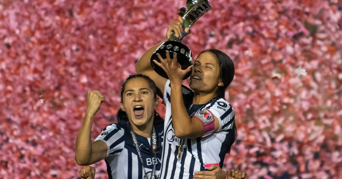 Desire Monsivais (i) y Rebeca Bernal (d) de Rayadas de Monterrey posan con el trofeo de campeonas luego de vencer a Tigres hoy, durante la final del Torneo de Apertura de la Liga Femenil Mx en el estadio Universitario de la ciudad de Monterrey (México). EFE/Miguel Sierra