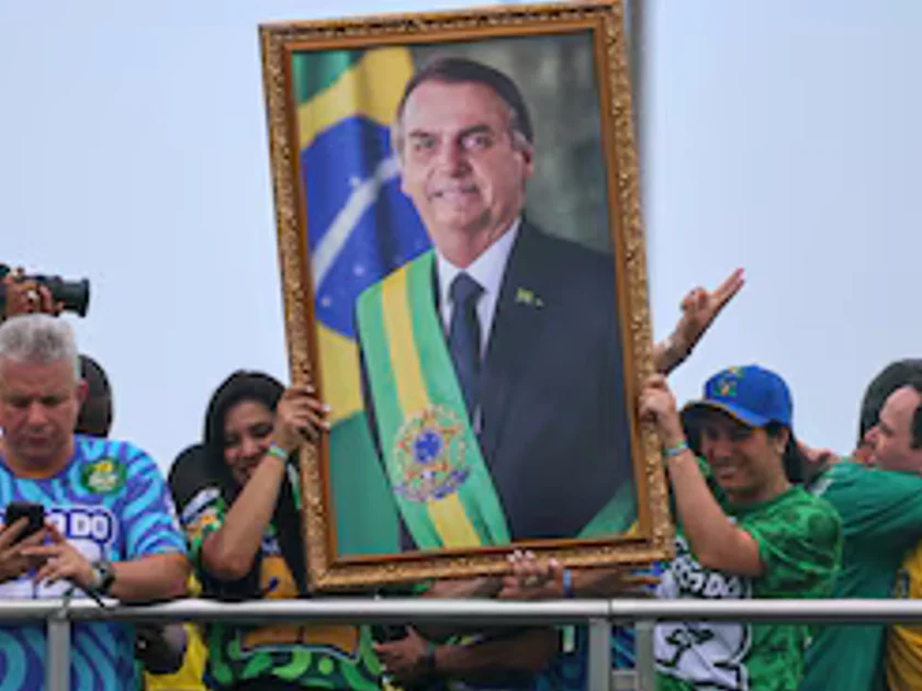 Varias personas sostienen un retrato del expresidente brasileño Jair Bolsonaro durante el mitin de cierre de la campaña presidencial de su hijo Flavio Bolsonaro, del Partido Liberal (PL), antes de la segunda vuelta de las elecciones presidenciales, en Río de Janeiro, Brasil, el 24 de octubre de 2026. REUTERS/Raquel Cunha