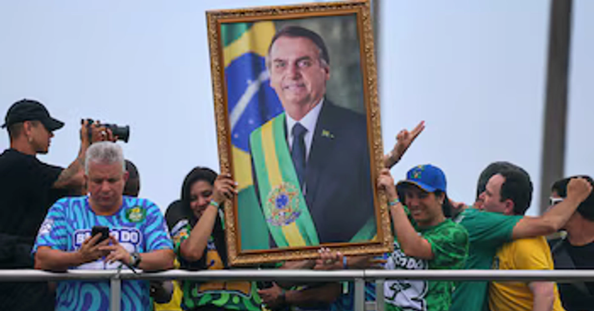 Varias personas sostienen un retrato del expresidente brasileño Jair Bolsonaro durante el mitin de cierre de la campaña presidencial de su hijo Flavio Bolsonaro, del Partido Liberal (PL), antes de la segunda vuelta de las elecciones presidenciales, en Río de Janeiro, Brasil, el 24 de octubre de 2026. REUTERS/Raquel Cunha