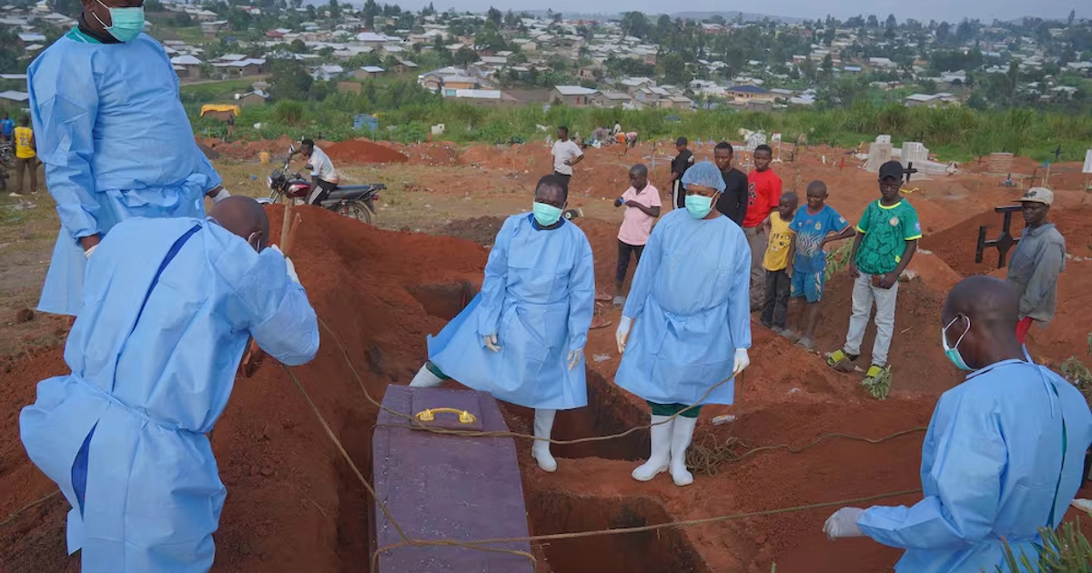 Personas con ropa protectora entierran a un niño de seis años que murió por ébola, en Bunia, en el este del Congo. FOTO: AP / DIEUDONNE DIROLE