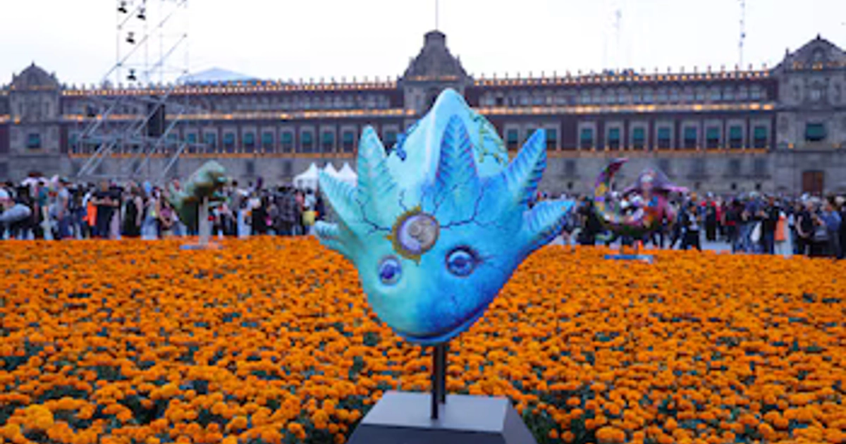 Una escultura rodeada por flores de cempasúchil forma parte de la megaofrenda instalada en el Zócalo de la Ciudad de México frente al Palacio Nacional. (Gobierno CDMX)