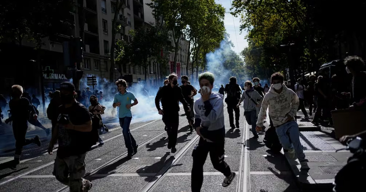 Estudiantes corren del gas lacrimógeno durante protestas contra el sistema educativo en Lyon, Francia. Foto: AP